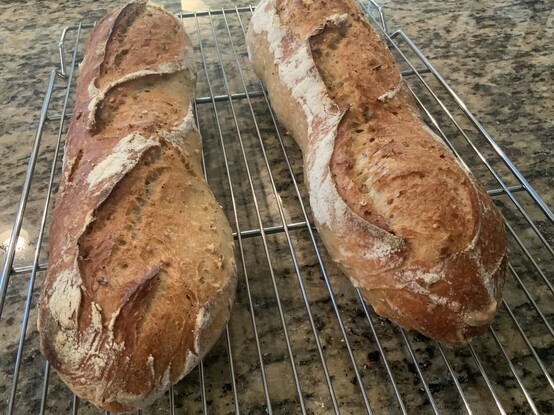 Two baguettes on a cooling rack.