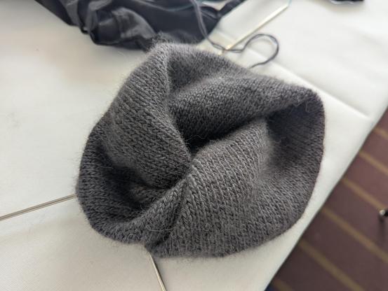 A knitted Moebius strip of dark grey yarn